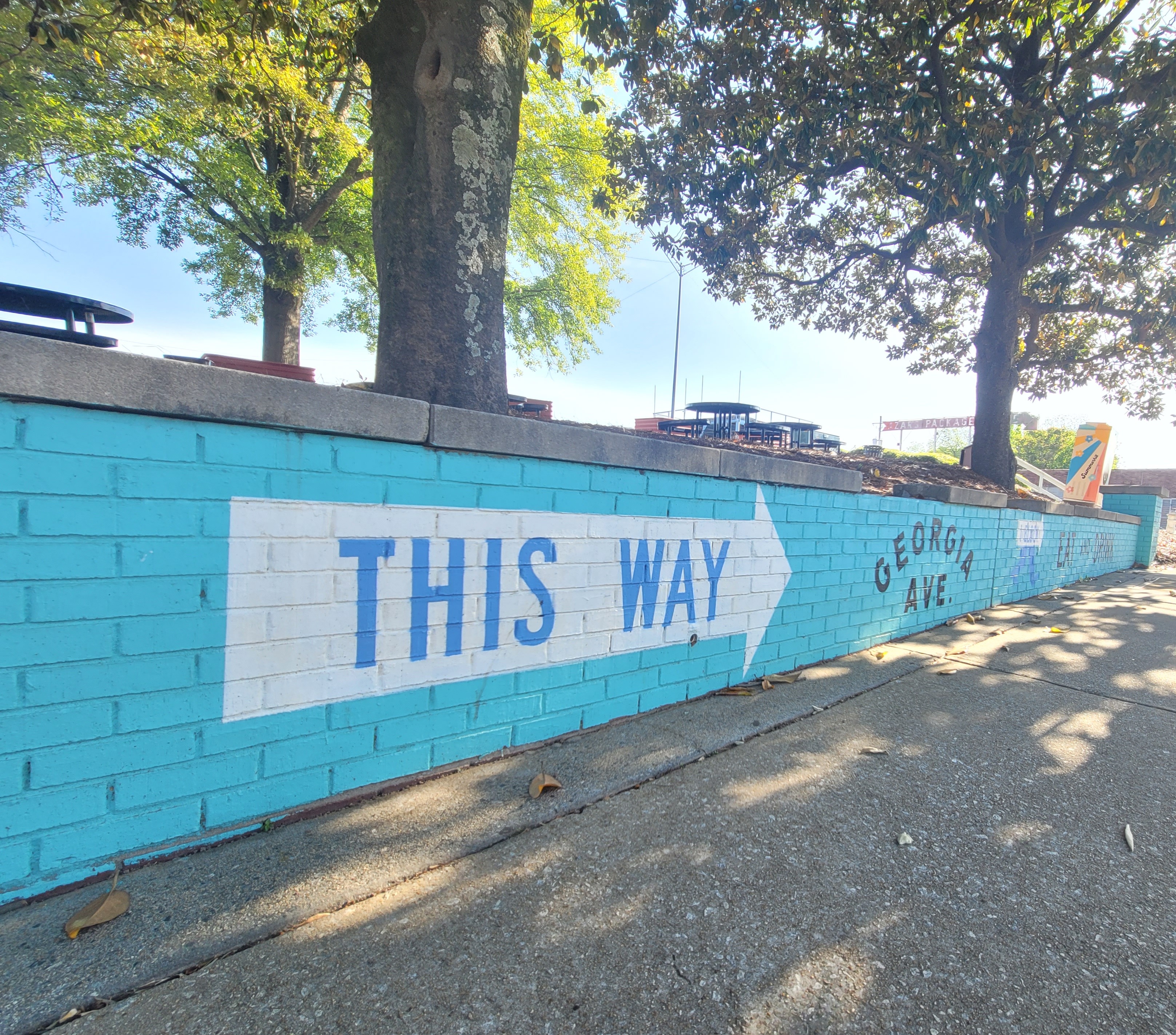 This way photo of arrow painted on brick wall